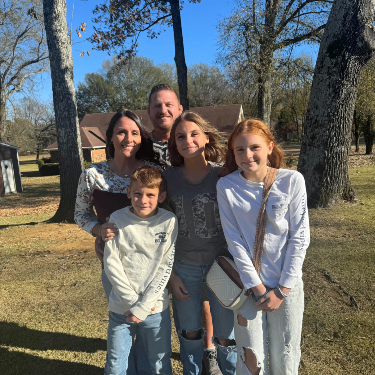 Portrait of head coach Bryant Murphy with his family outdoors